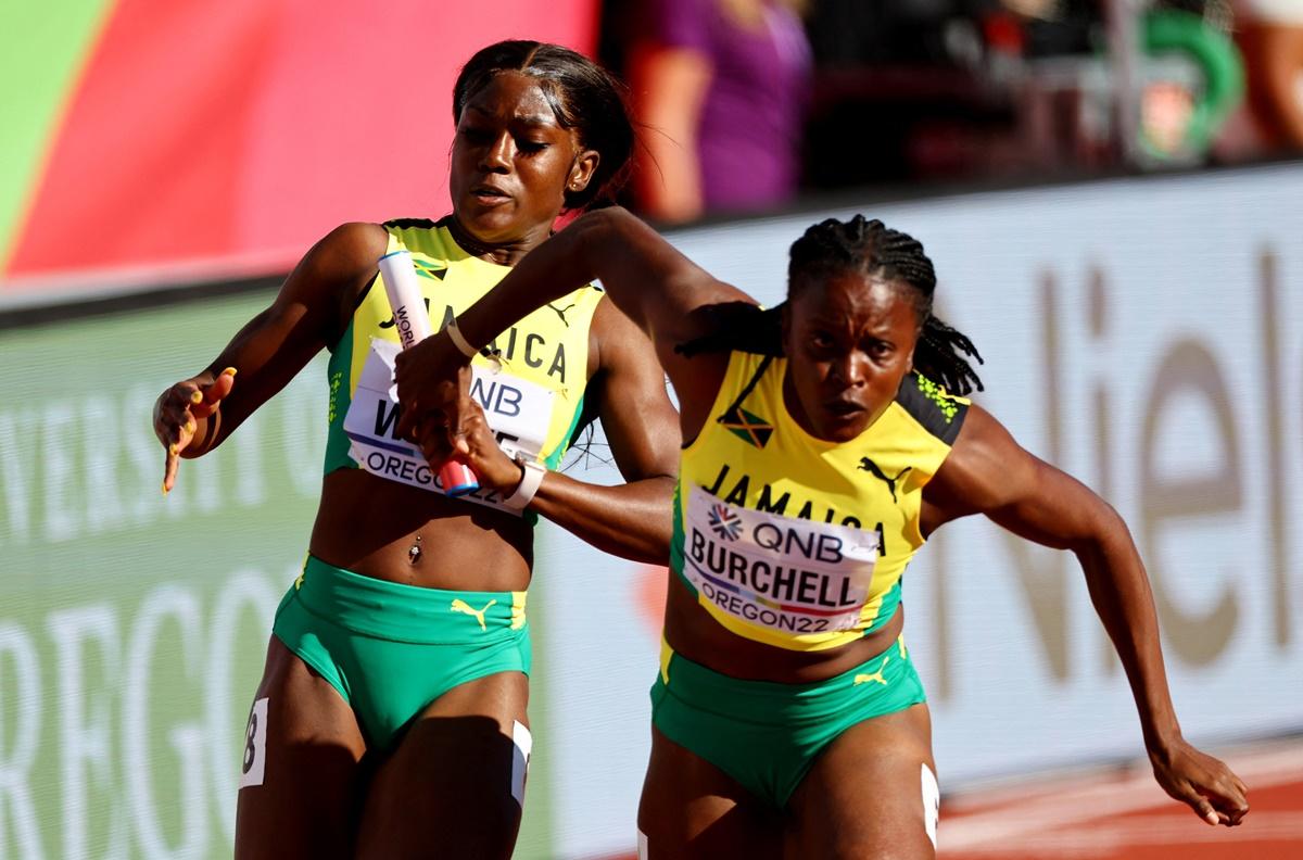 Jamaica's Natalliah Whyte passes the baton to Remona Burchell during their heat.