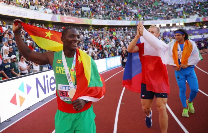 Anderson Peters, Neeraj Chopra and Jakub Vadlejch do a lap of honour after the medal  ceremony.