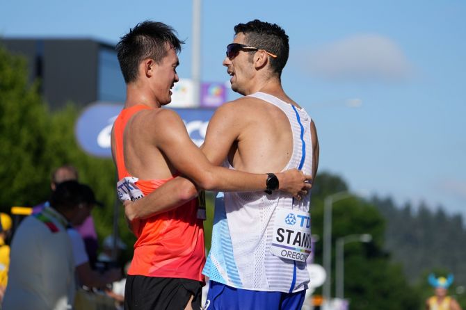 Italy's Massimo Stano, right, and Japan's Masatora Kawano embrace at the finish after placing first and second in the 35km race walk at the World Athletics Championships in Eugene, Oregano.