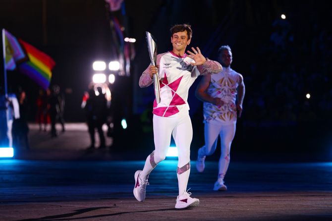LGBTQ+ activist and British Olympic champion Tom Daley carries the Queen’s Baton during the Opening Ceremony.