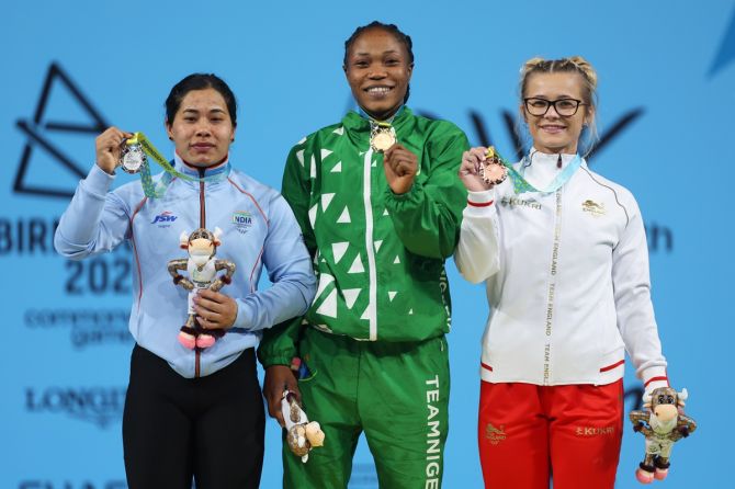 (L-R) India's Bindyarani Devi Sorokhaibam (silver), Nigeria's Adijat Adenike Olarinoye (gold) and England's Fraer Morrow (bronze) pose with their medals from the women's 55kg weightlifting.