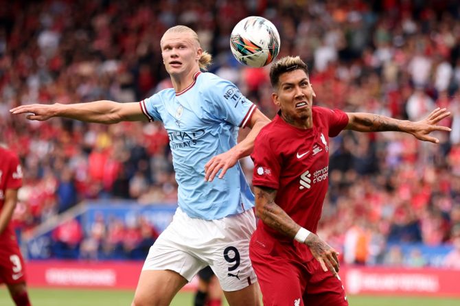Roberto Firmino battles for possession with Manchester City's Erling Haaland. 