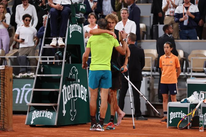 Alexander Zverev and Rafael Nadal embrace as the German returns on crutches to confirm his retirement.
