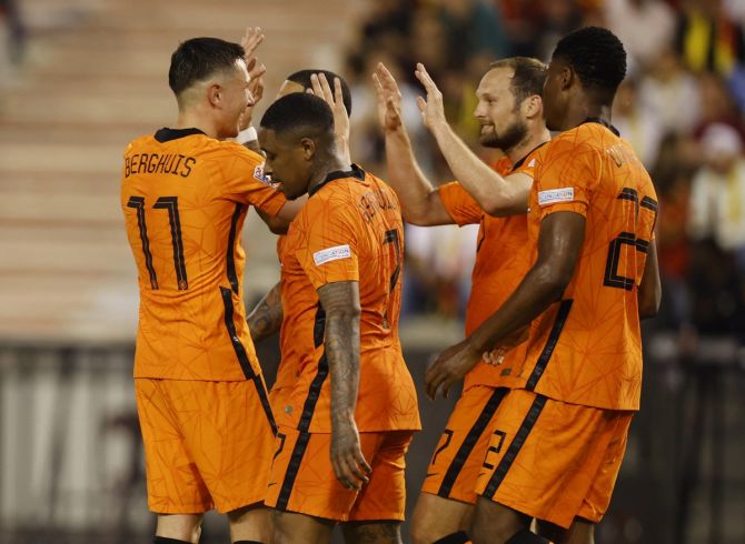 Denzel Dumfries celebrates with teammates after scoring the Netherlands' third goal.