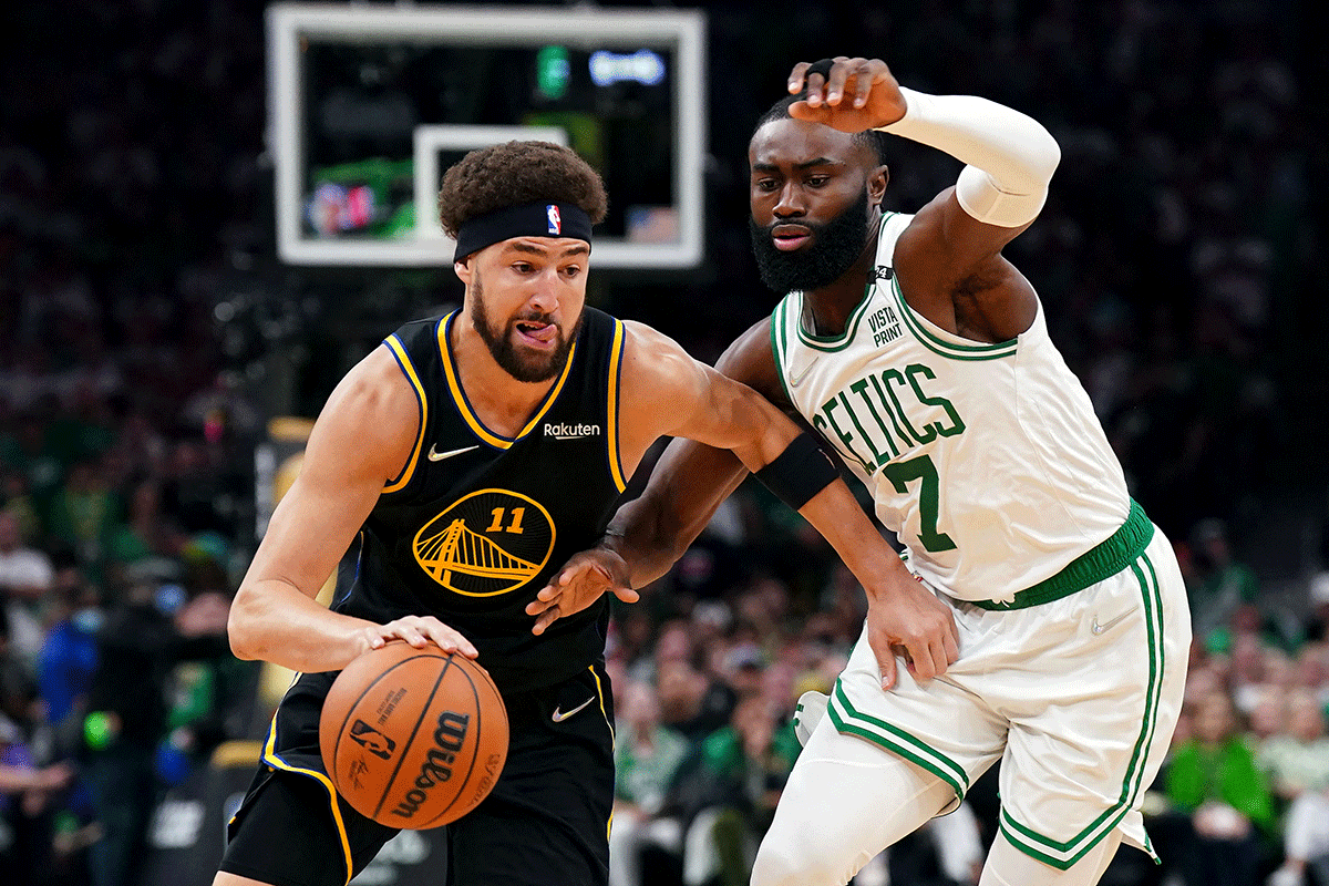 Golden State Warriors guard Klay Thompson (11) dribbles the ball against Boston Celtics guard Jaylen Brown (7)