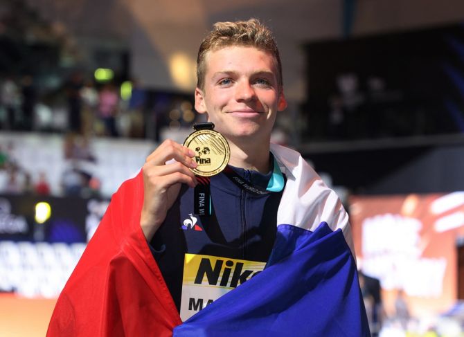 France's Leon Marchand celebrates on the podium with his gold medal from the men's 400m medley.