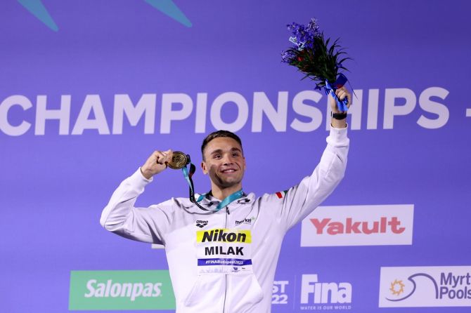 Hungary's Kristof Milak celebrates on the podium after winning the men's 100m butterfly gold.