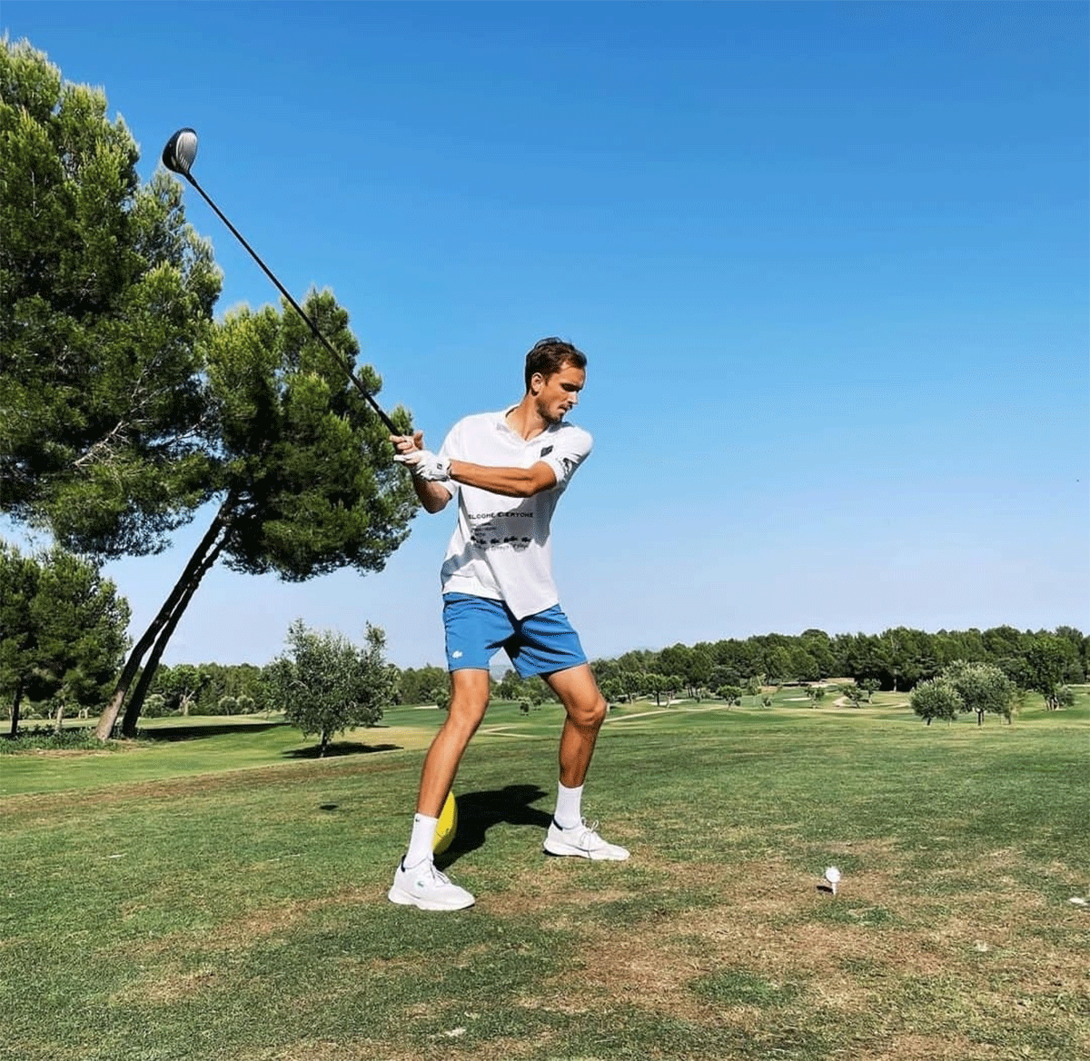 Daniil Medvedev tees off at a golf course