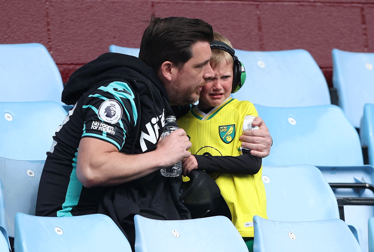 Norwich City fans wear a dejected look after being relegated from the Premier League after the match against Aston Villa at Villa Park in Birmingham , Britain