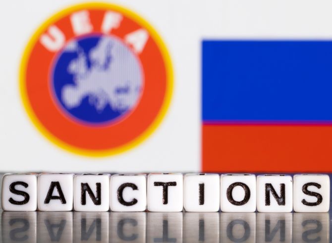 Plastic letters arranged to read 'Sanctions are placed in front the UEFA logo and Russian flag colours in this illustration.