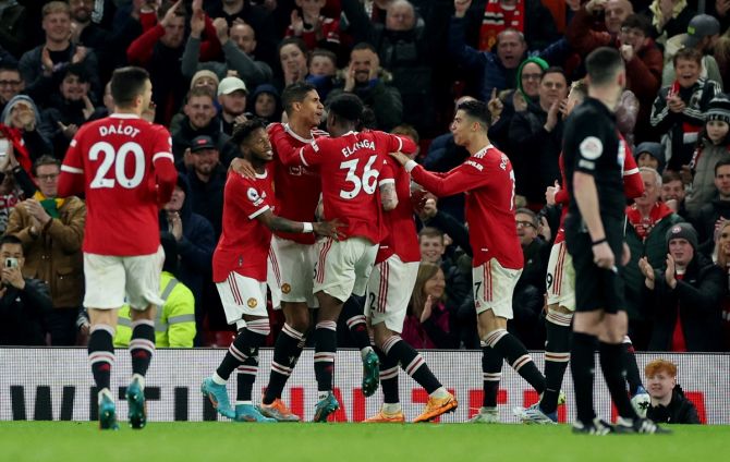 Raphael Varane is congratulated by his Manchester United teammates after scoring their third goal, his first for the club.
