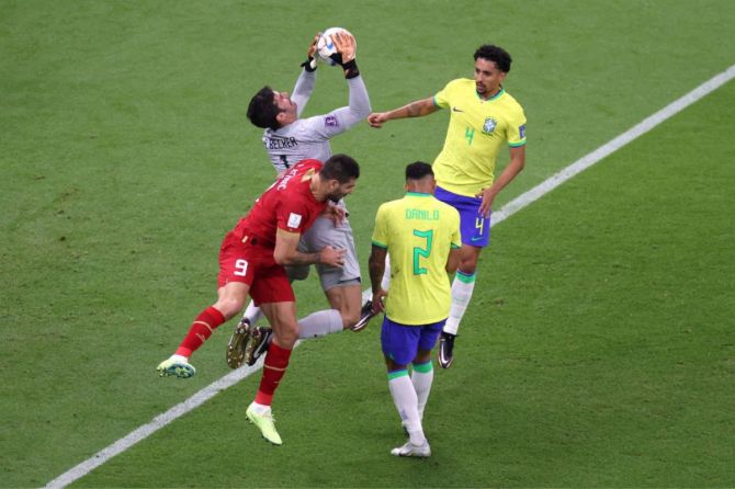 Alisson Becker of Brazil makes a save against Aleksandar Mitrovic of Serbia