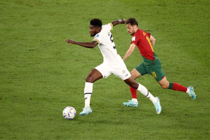 Thomas Partey of Ghana controls the ball under pressure of Bernardo Silva