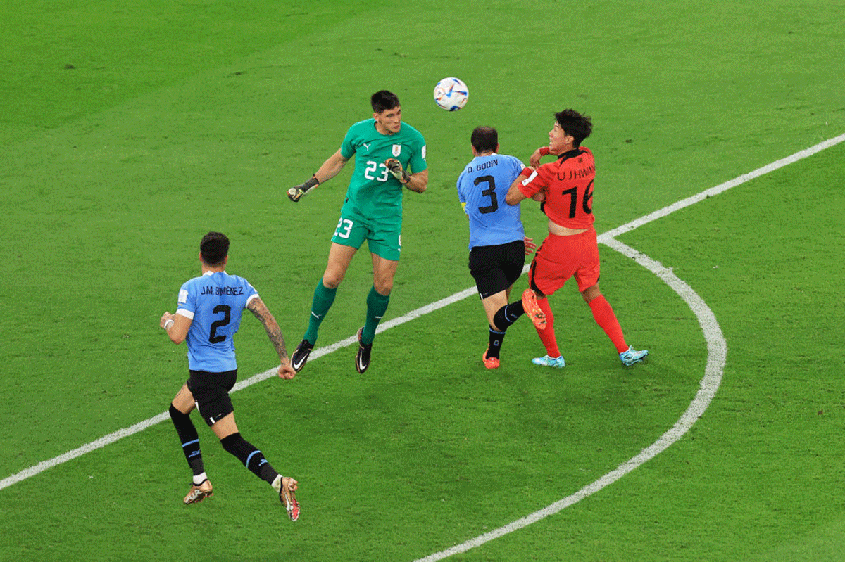 Uruguay's Sergio Rochet (2 from left) and Diego Godin defend an attempt by South Korea's Uijo Hwang