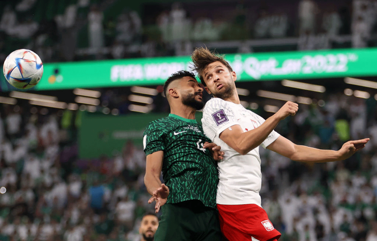 Saudi Arabia's Abdulelah Al-Amri competes for a header against Poland's Bartosz Bereszynski