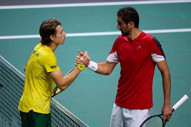 Australia's Alex de Minaur, left, forced the decider when he overpowered Marin Cilic in the second singles.