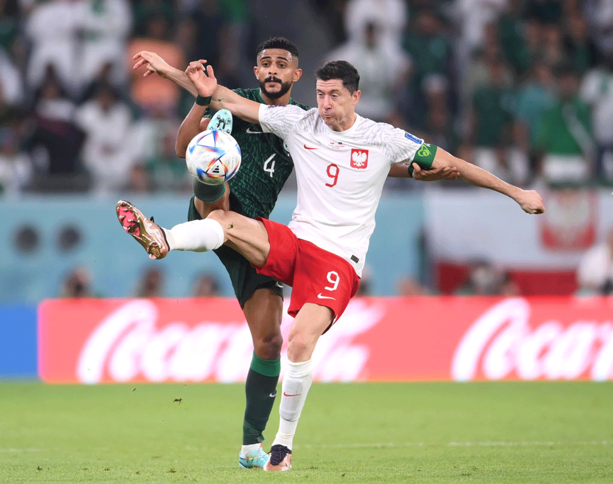 Poland's Robert Lewandowski Saudi Arabia's Abdulelah Al-Amri compete for the ball