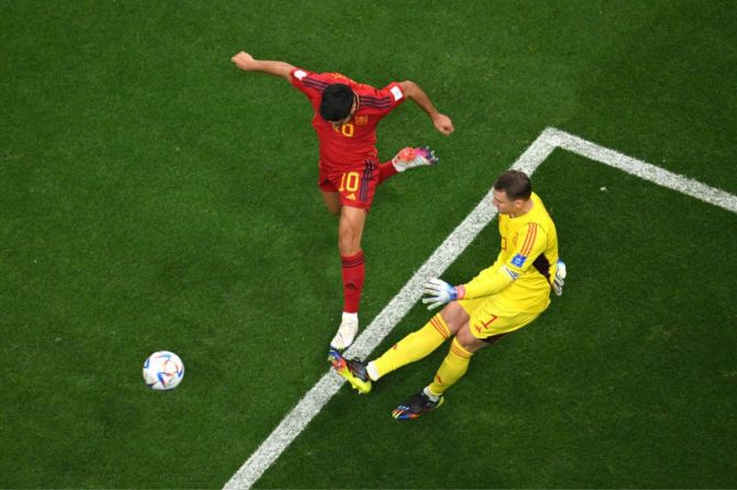 Marco Asensio of Spain and Manuel Neuer of Germany compete for the ball 