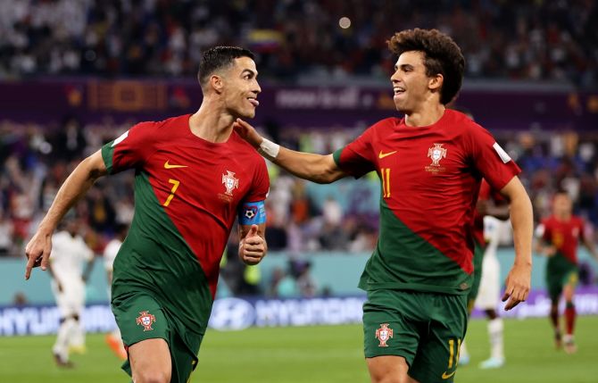 Cristiano Ronaldo celebrates with Joao Felix after scoring Portugal's first goal from the penalty spot during the World Cup Group H match against Ghana, at Stadium 974 in Doha, Qatar. 