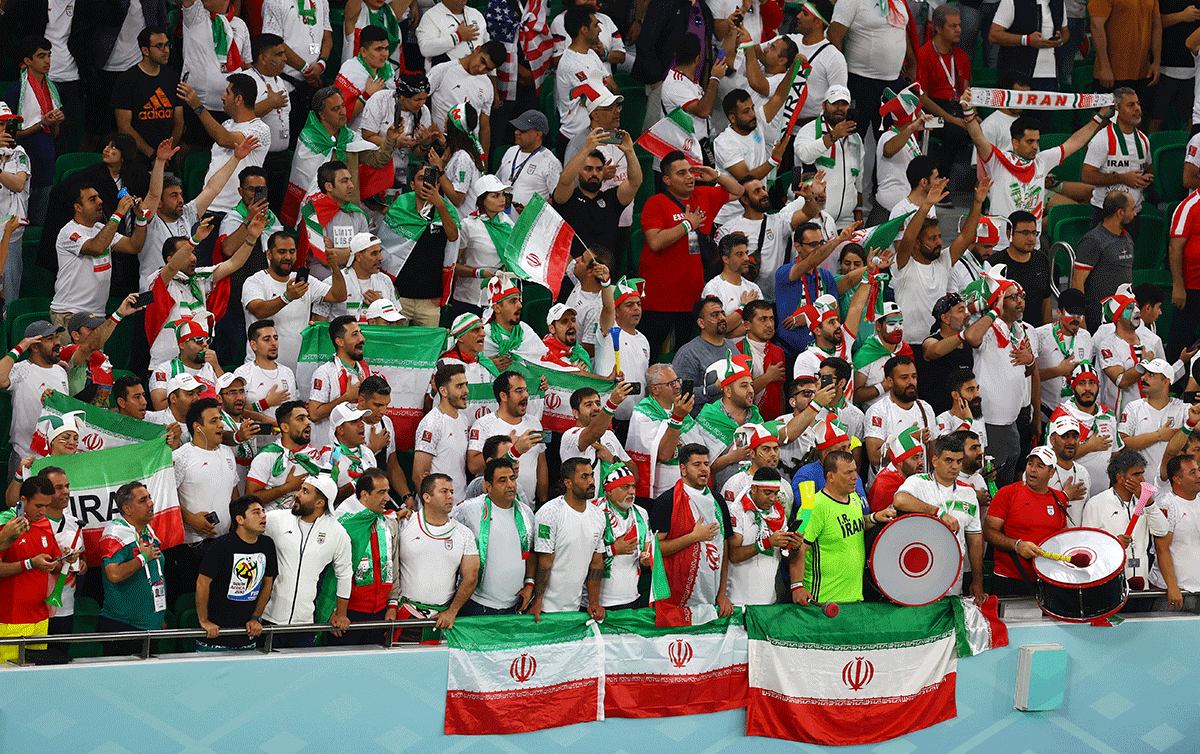 Iran fans sing the national anthem inside the stadium before the match 