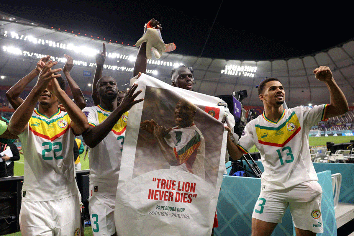 Senegal players applaud fans with a banner of Papa Bouba Diop, on the 2nd anniversary of his death, after their 2-1 victory over Ecuador