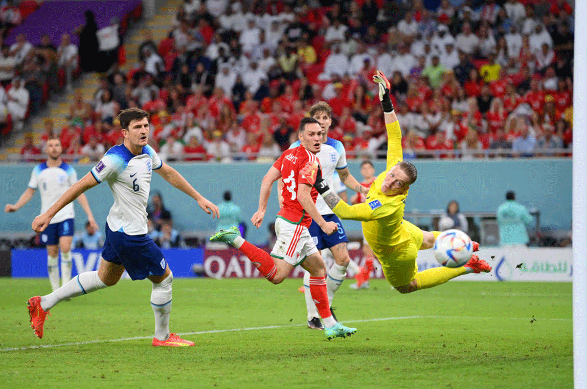 England's Jordan Pickford dives for the ball to put in a save