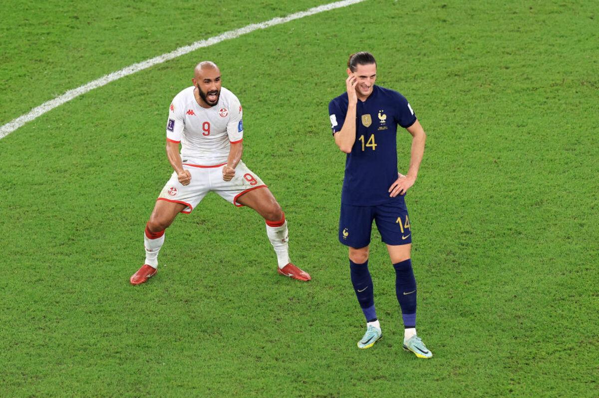 Tunisia's Issam Jebali celebrates after the 1-0 win as France's Adrien Rabiot reacts.