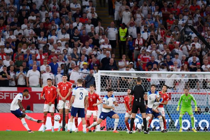 Marcus Rashford curls his free-kick past Wales goalkeeper Danny Ward for England's opening goal during the World Cup Group B match at Ahmad Bin Ali Stadium, in Doha, on Tuesday.