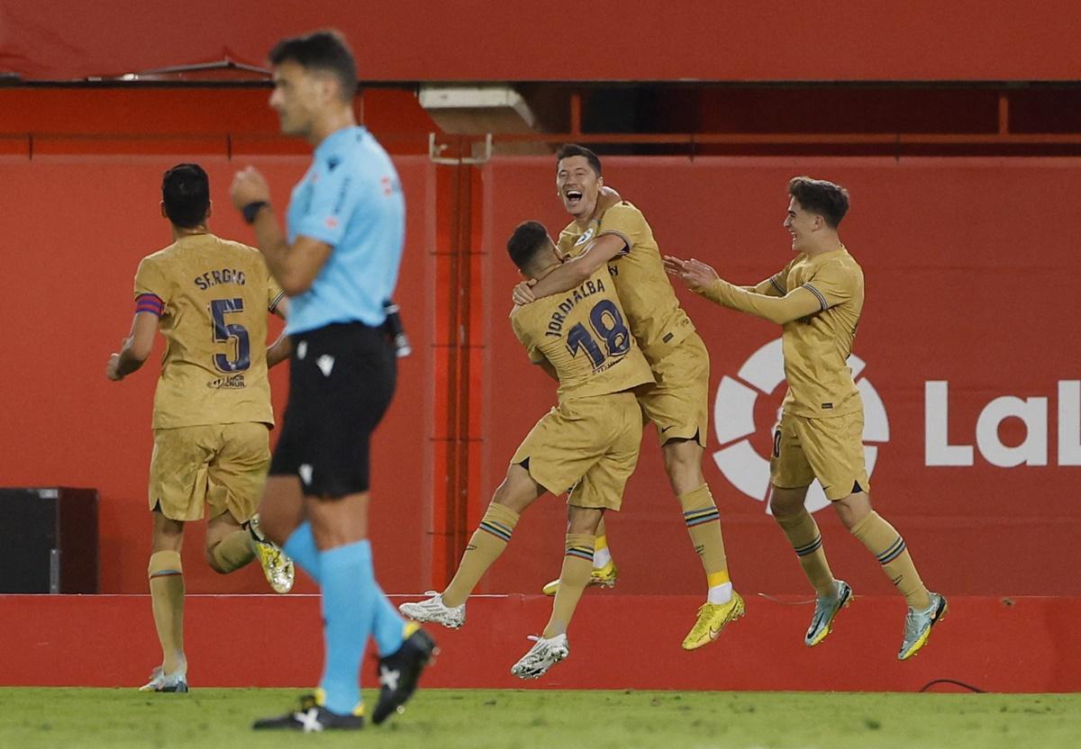 Robert Lewandowski celebrates with Jordi Alba and Gavi after scoring Barcelona's only goal of the match against Mallorca at Mallorca Stadium, Palma, Mallorca, on Saturday.