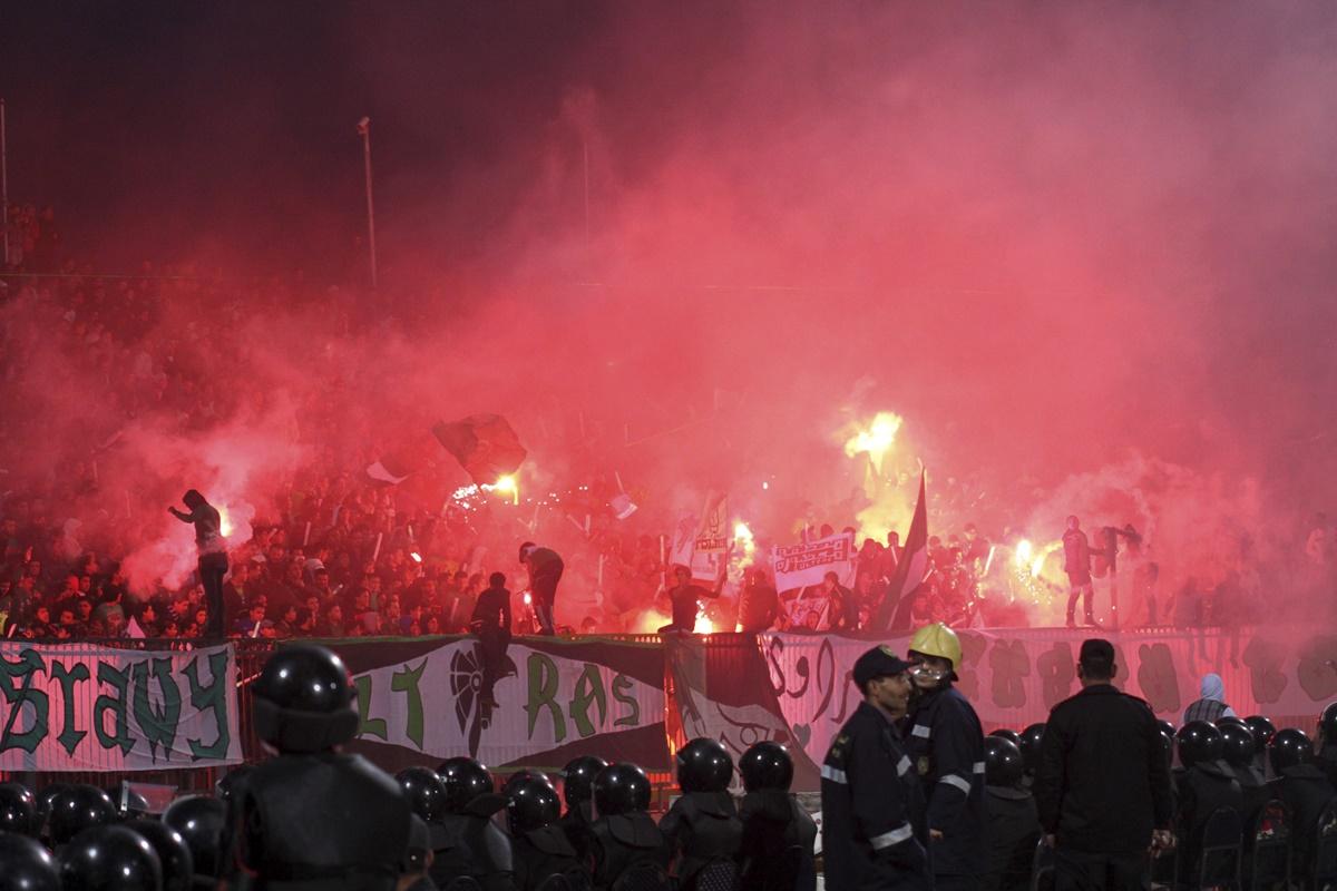 Police officers react as chaos erupts at a soccer stadium in Port Said city, Egypt, February 1, 2012. 73 people were killed and at least 1,000 injured after the pitch invasion.