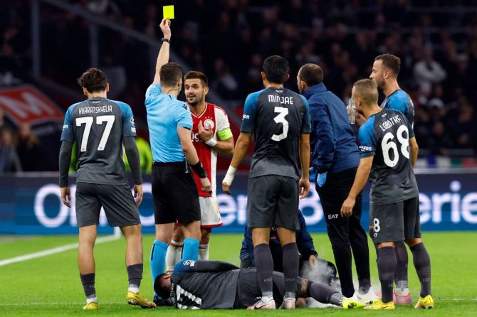  Ajax Amsterdam's Dusan Tadic is shown a yellow card by the referee 