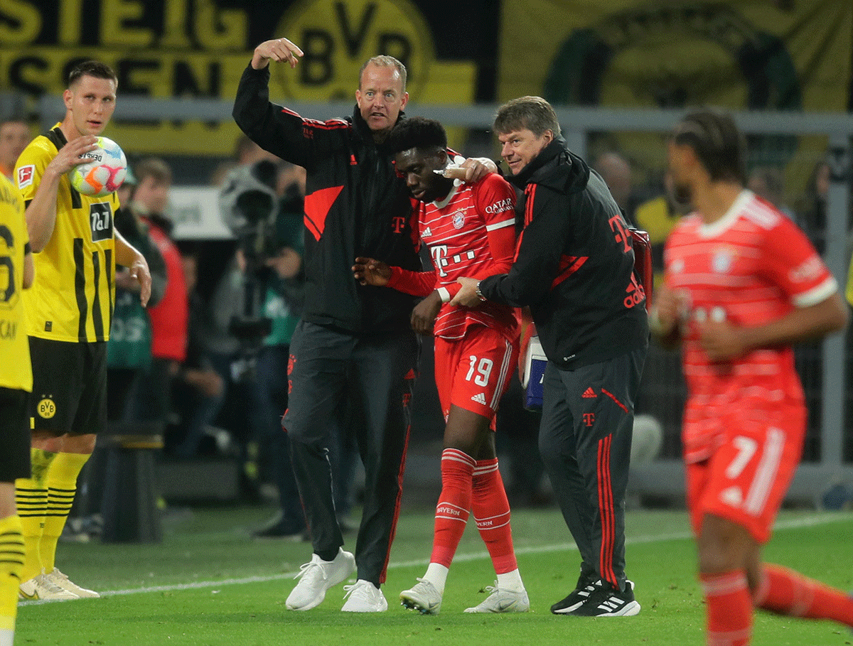 Bayern Munich's Alphonso Davies receives medical attention after sustaining an injury during the Bundesliga match against Borussia Dortmund at Signal Iduna Park, Dortmund, Germany, on Saturday 