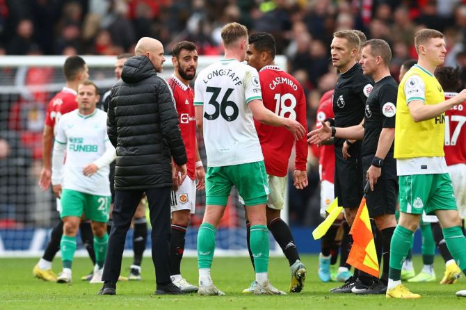 Newcastle United's Sean Longstaff speaks to referee Craig Pawson after the match as Manchester United manager Erik ten Hag looks on