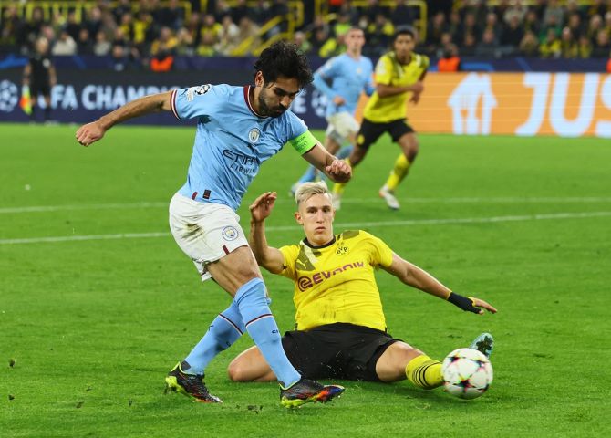 Manchester City's Ilkay Gundogan is checked in his stride by Borussia Dortmund's Nico Schlotterbeck during the Champions League Group G match, at Signal Iduna Park, Dortmund, Germany.