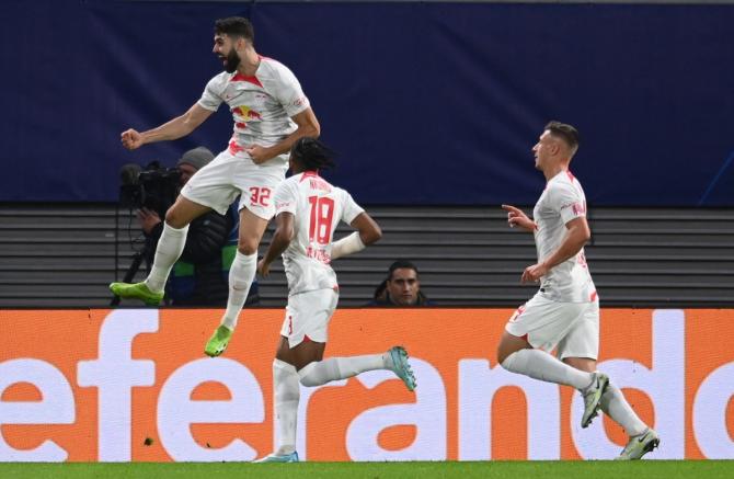 Josko Gvardiol celebrates scoring RB Leipzig's first goal with Christopher Nkunku and Willi Orban during the Champions League Group F match against Real Madrid at Red Bull Arena, Leipzig, Germany.