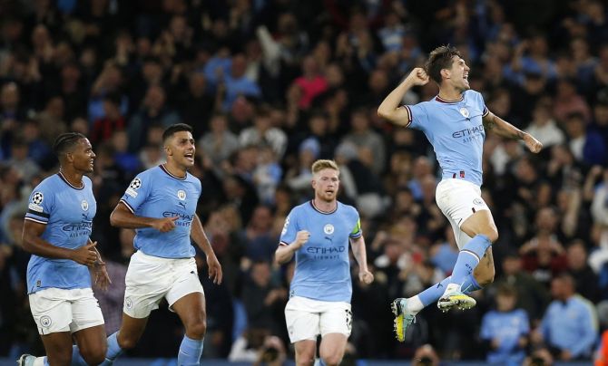 John Stones celebrates scoring Manchester City's first goal with Manuel Akanji and Rodri.