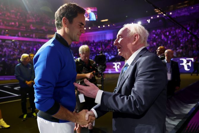 Roger Federer speaks with Rod Laver after the match.