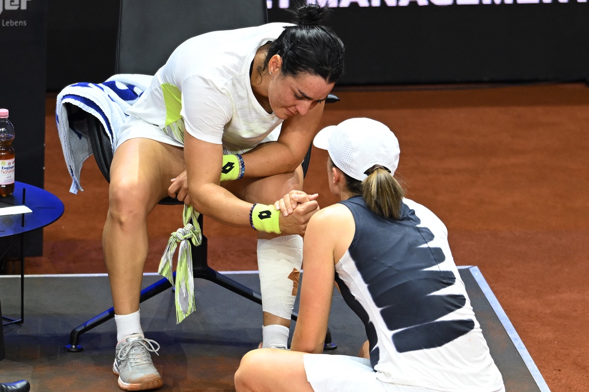 Tunisia's Ons Jabeur speaks with Poland's Iga Swiatek after withdrawing from their semi-final at the WTA 500 Stuttgart Open at Porsche Arena, Stuttgart, Germany, on Saturday.