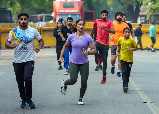 Vinesh Phogat and her fellow athletes are joined by a young supporter on their morning jog