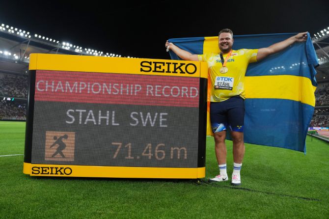 Sweden's Daniel Stahl poses with the Championship Record sign after winning gold