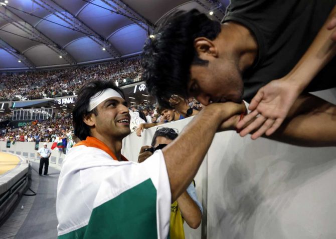 A fan kisses the hand of Neeraj Chopra after the Indian won the javelin throw gold on Sunday, August 27