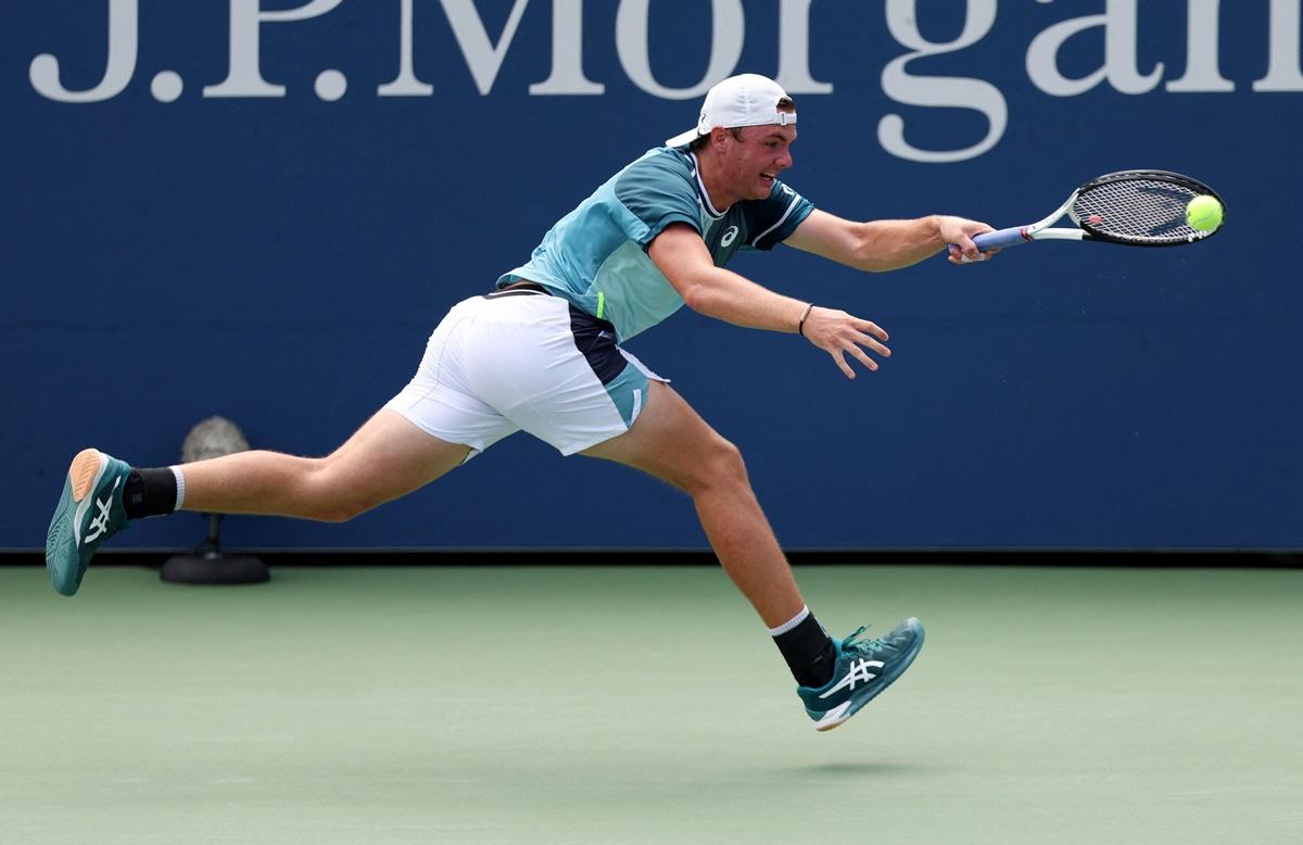 Switzerland's Dominic Stricker stretches to return against Greece's Stefanos Tsitsipas.