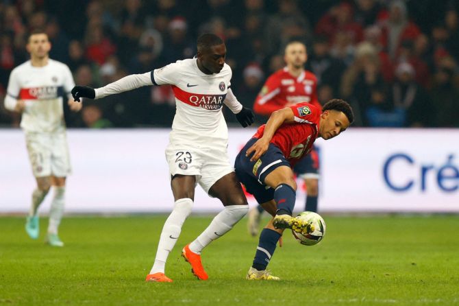 Paris St Germain's Randal Kolo Muani in action with Lille's Tiago Santos during their Ligue 1 match at Stade Pierre-Mauroy, Villeneuve-d'Ascq, France