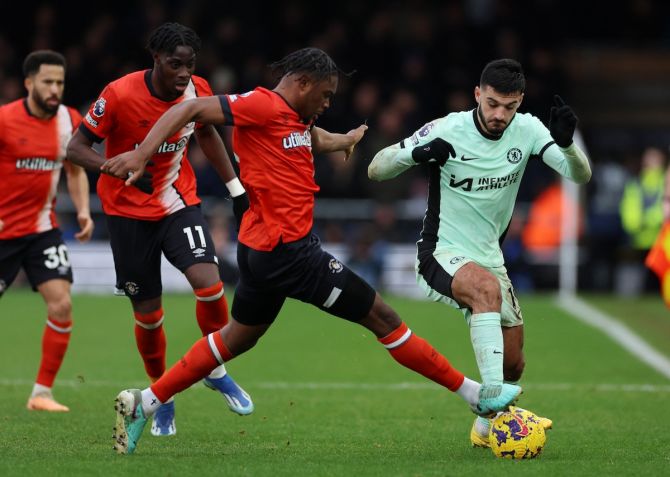 Chelsea's Armando Broja in action with Luton Town's Teden Mengi and Elijah Adebayo
