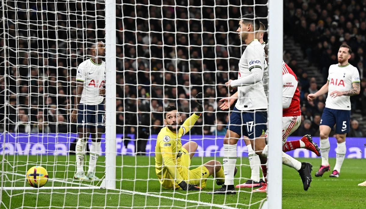 Tottenham Hotspur goalkeeper Hugo Lloris watches as he deflects the ball into his own goal.