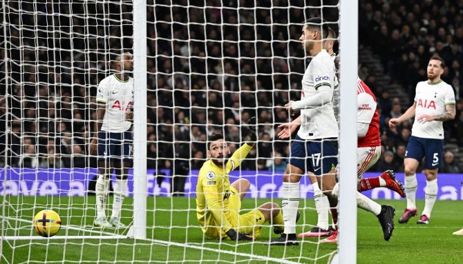Tottenham Hotspur goalkeeper Hugo Lloris watches as he deflects the ball into his own goal.