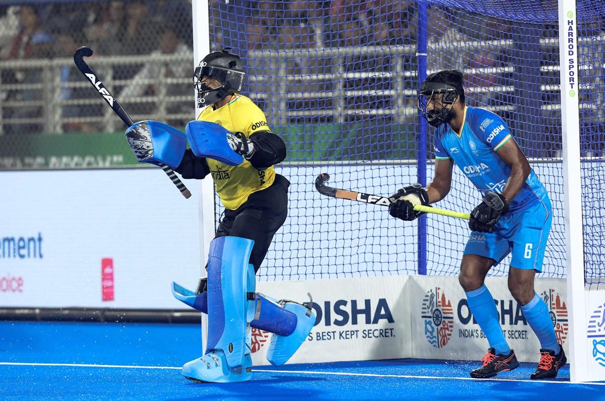 India's goalkeeper Sreejesh and defender Surender Kumar prepare to defender an England penalty-corner.