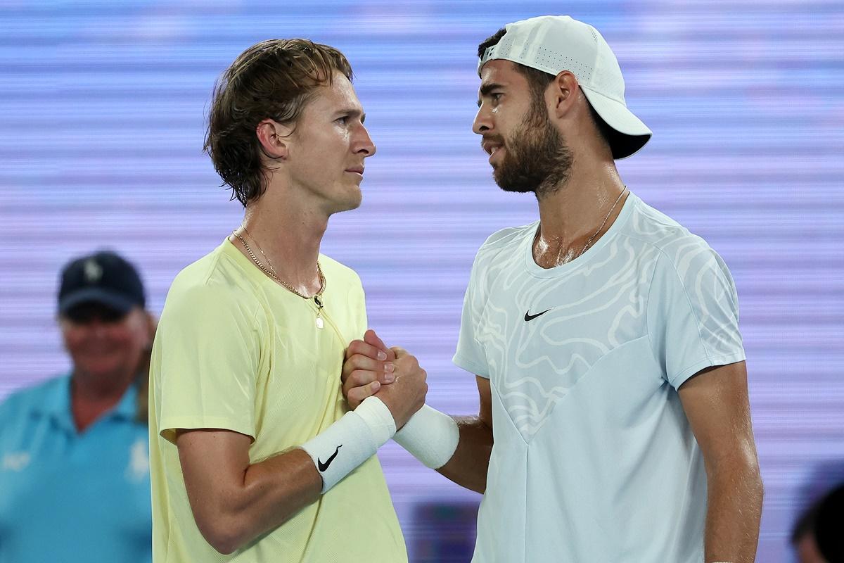 Karen Khachanov empathises with Sebastian Korda after they embrace at the net.