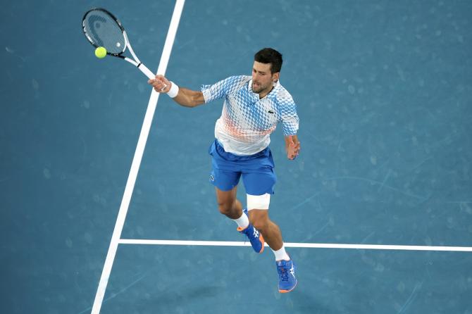 Novak Djokovic rushes to the net to cut off a return from Andrey Rublev.