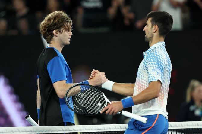 Andrey Rublev and Novak Djokovic embrace at the net after their men's singles quarter-final.